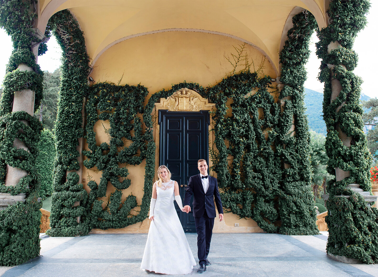 Villa del Balbianello wedding: elegant bride and groom standing on the flowery porch